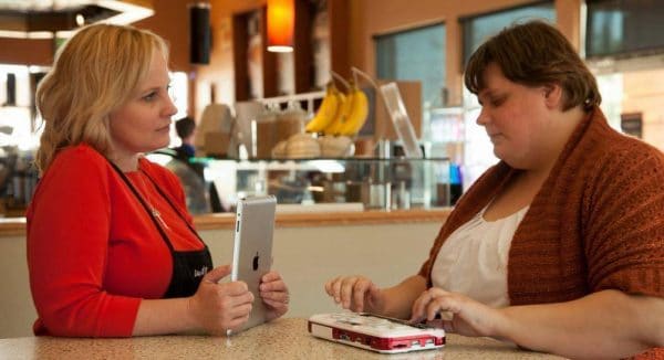 une femme avec le Bloc note Braille Sense U2 Perkins posé sur une table