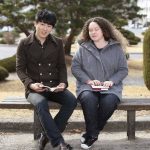 Deux étudiants sur un banc dont une aveugle avec un Braille Sense U2 mini