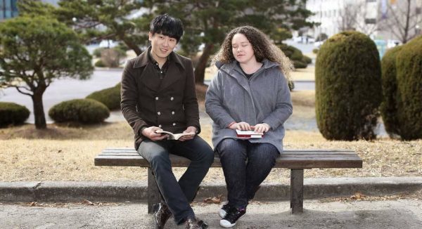 Deux étudiants sur un banc dont une aveugle avec un Braille Sense U2 mini