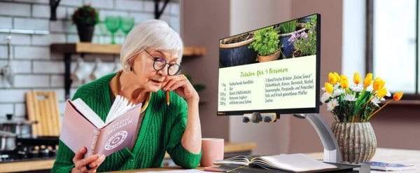 Une femme senior lit avec le téléagrandisseur MEZZO