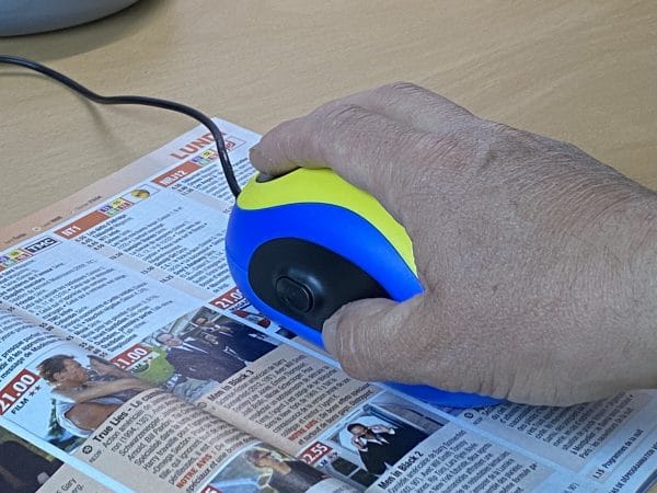 Souris Vidéo Loupe sur magazine TV tenue à la main