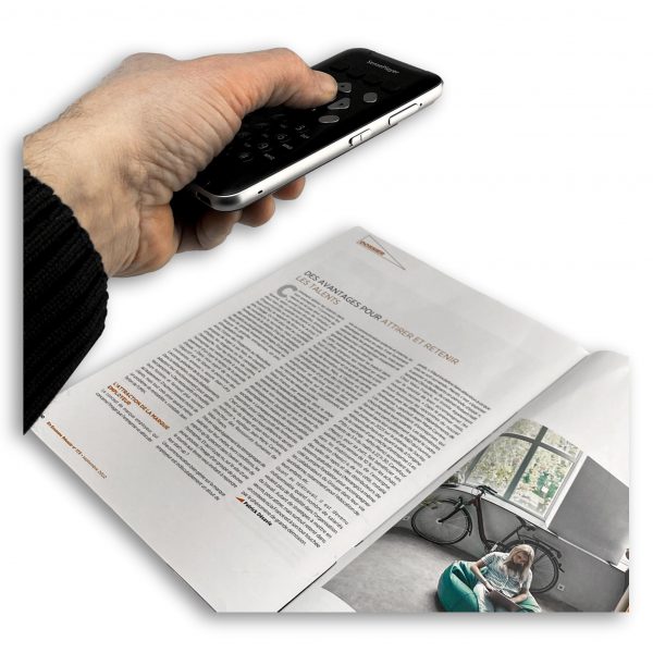 SensePlayer machine lire avec OCR, tenue à la main au dessus d'un magazine